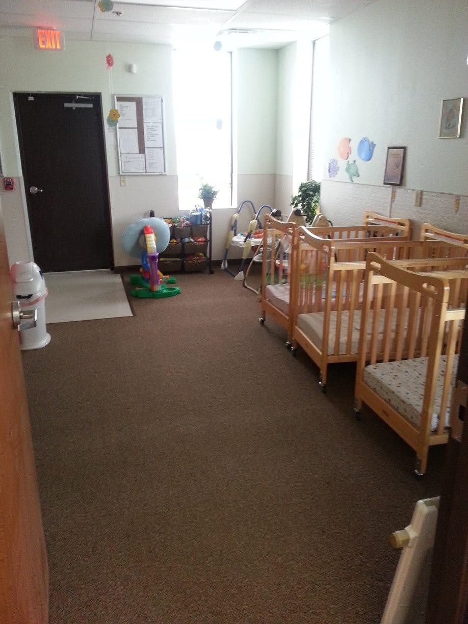 Empty cribs in a room with a door and window