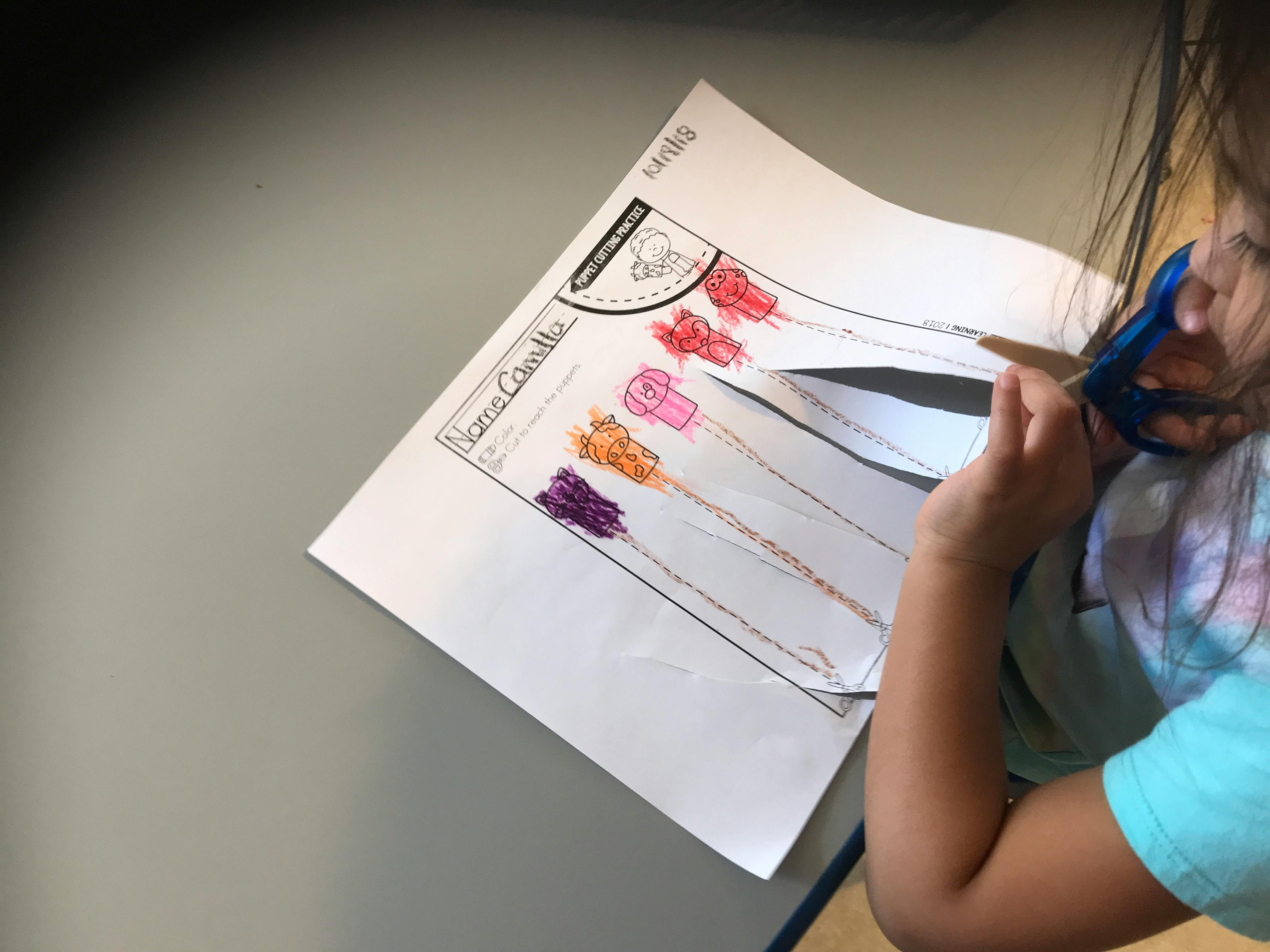 Child cutting paper with scissors