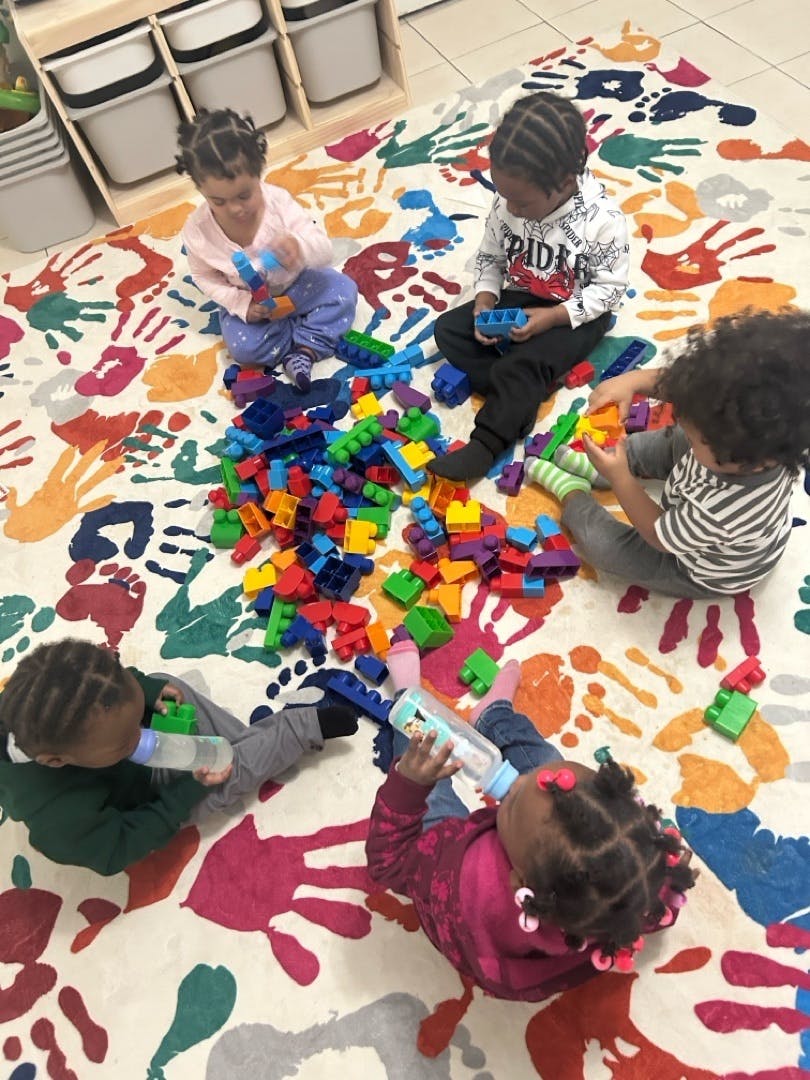 Children playing with colorful building blocks on a patterned rug