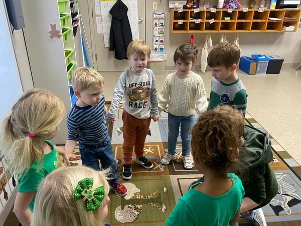 Group of children standing in a circle in a classroom