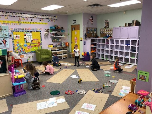 Children playing on the floor in a classroom