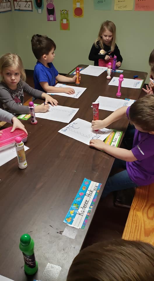 Children drawing at a table in a classroom