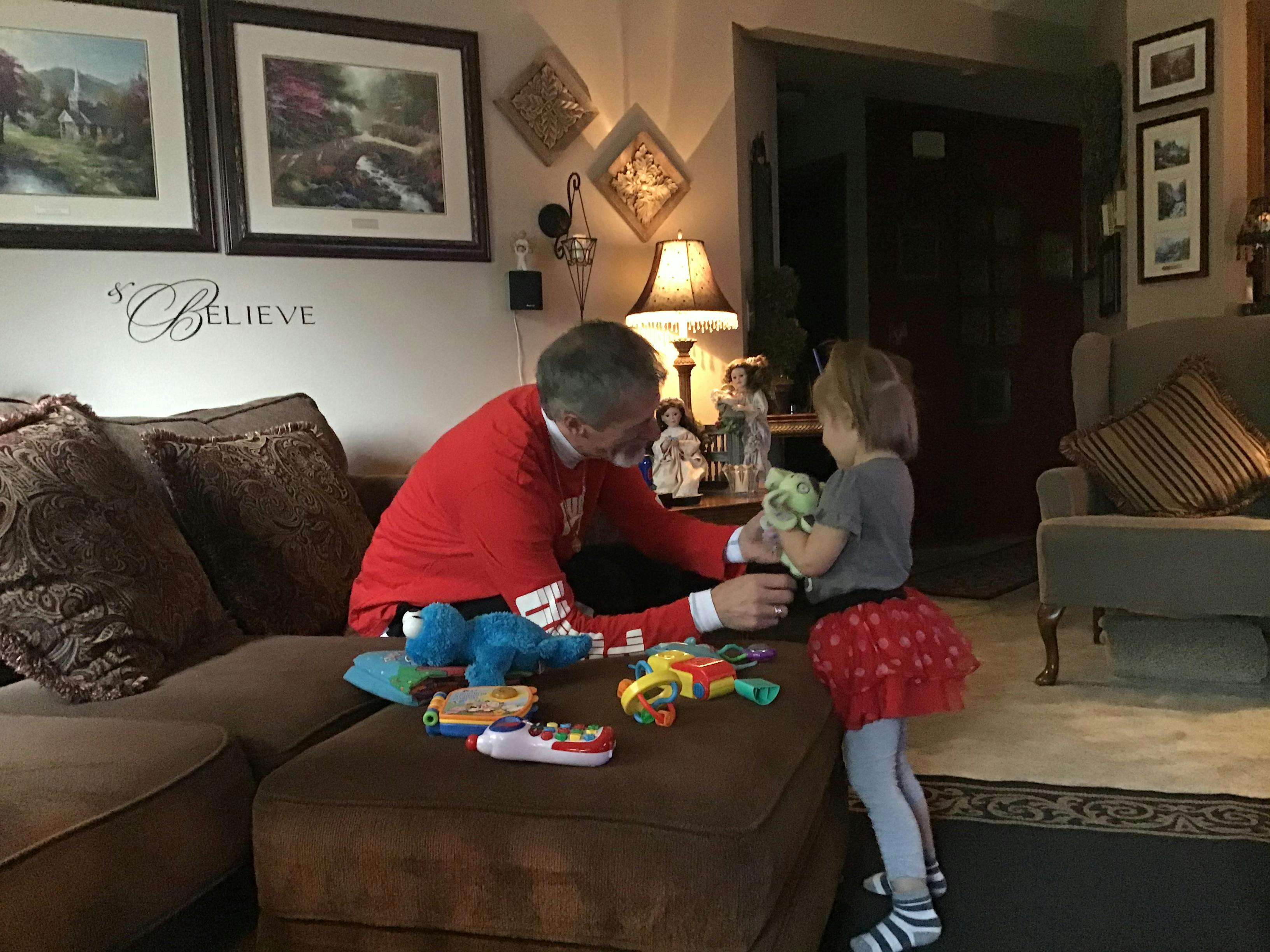 Person in red shirt playing with a child