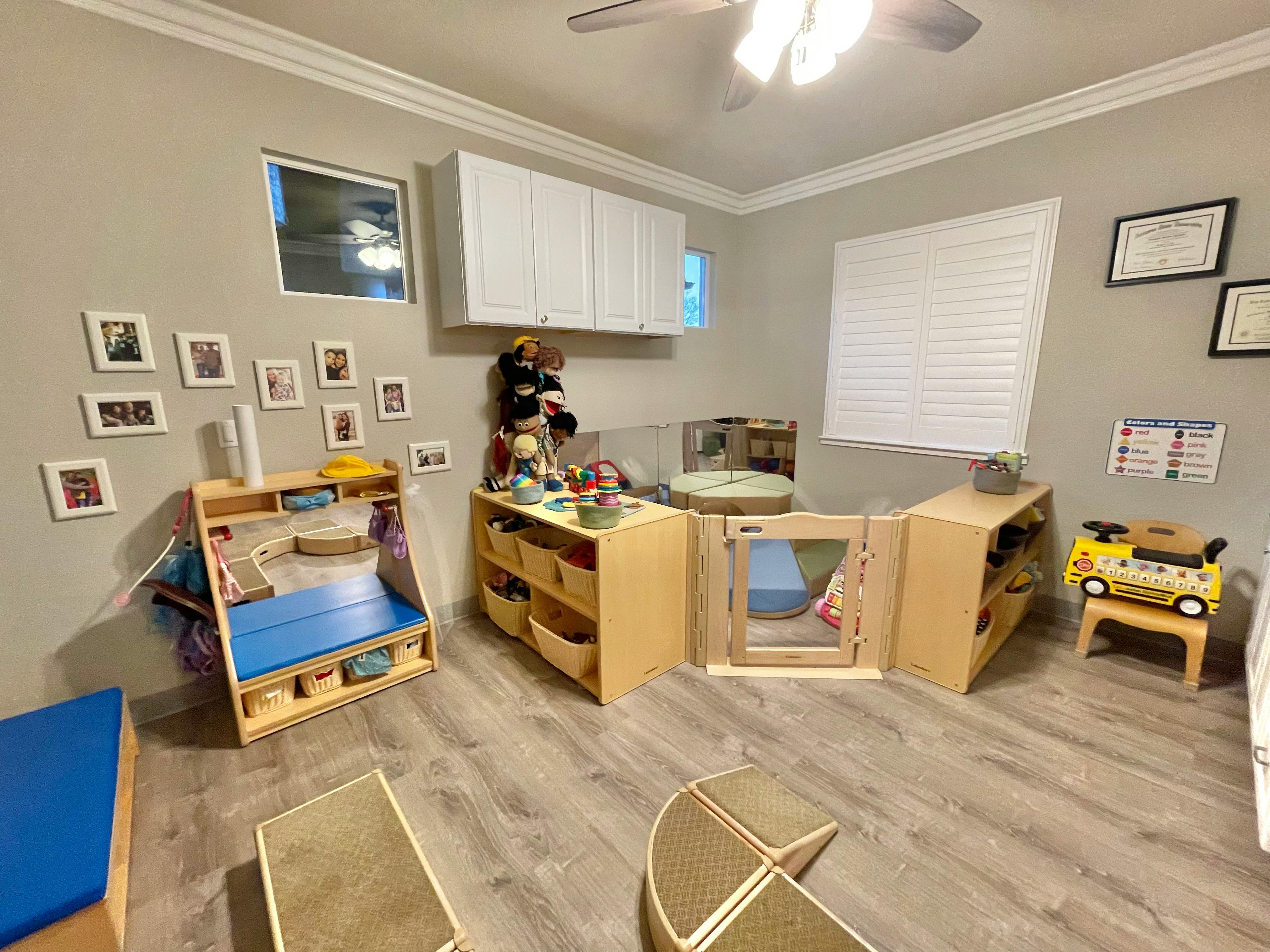 Playroom with wooden furniture, toys, and a small gate