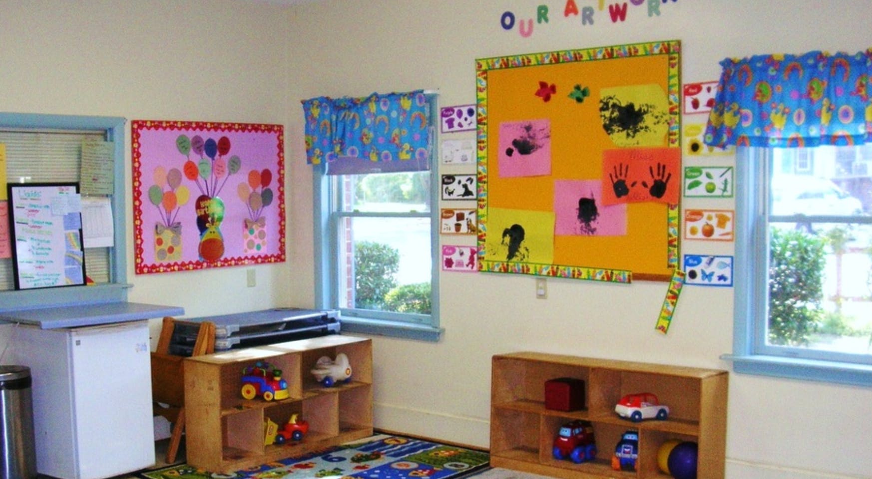 Classroom with bulletin boards, windows, and toy shelves