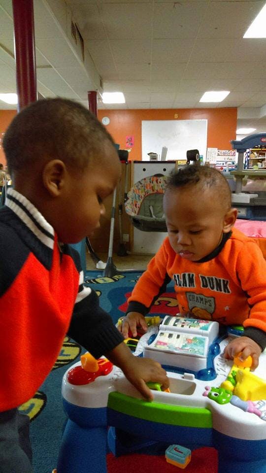 Two children playing with a toy cash register