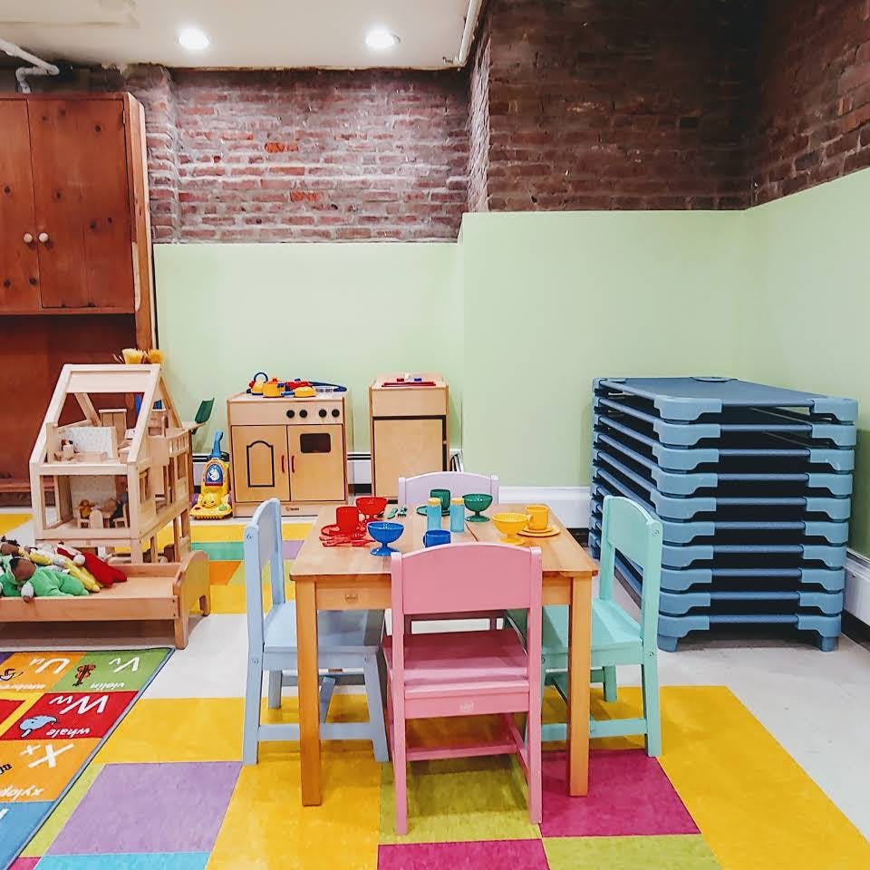 Playroom with small table and chairs, dollhouse, and play kitchen