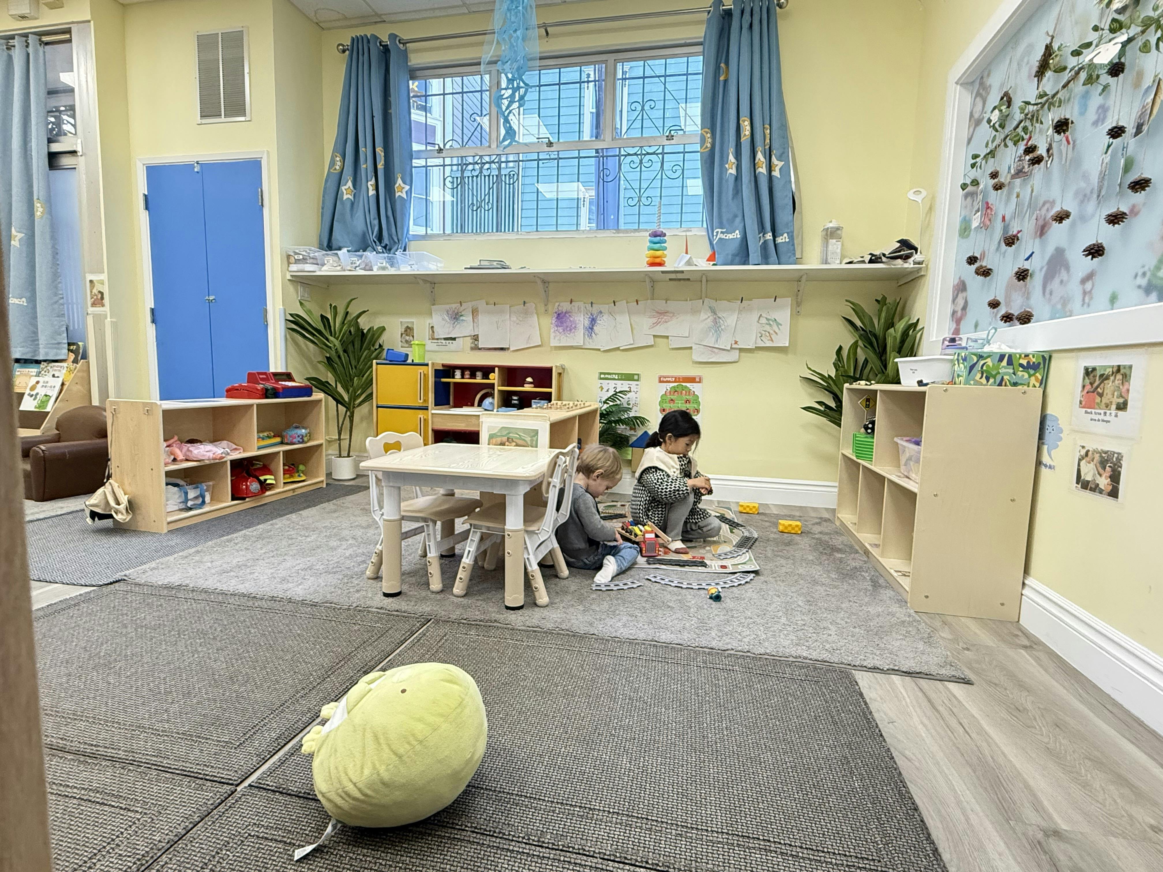 Two children playing on the floor in a classroom