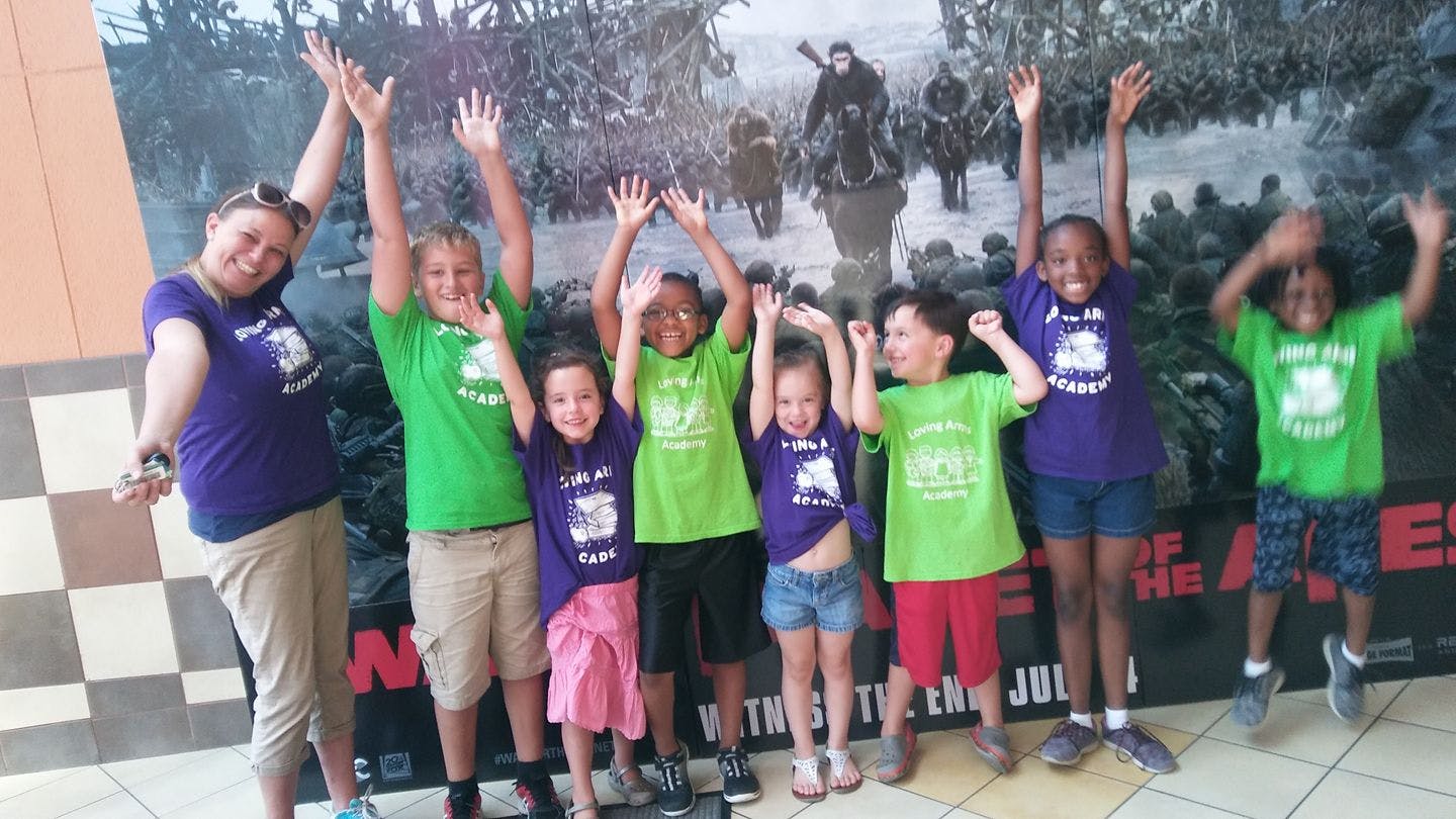 Adult and children raising hands