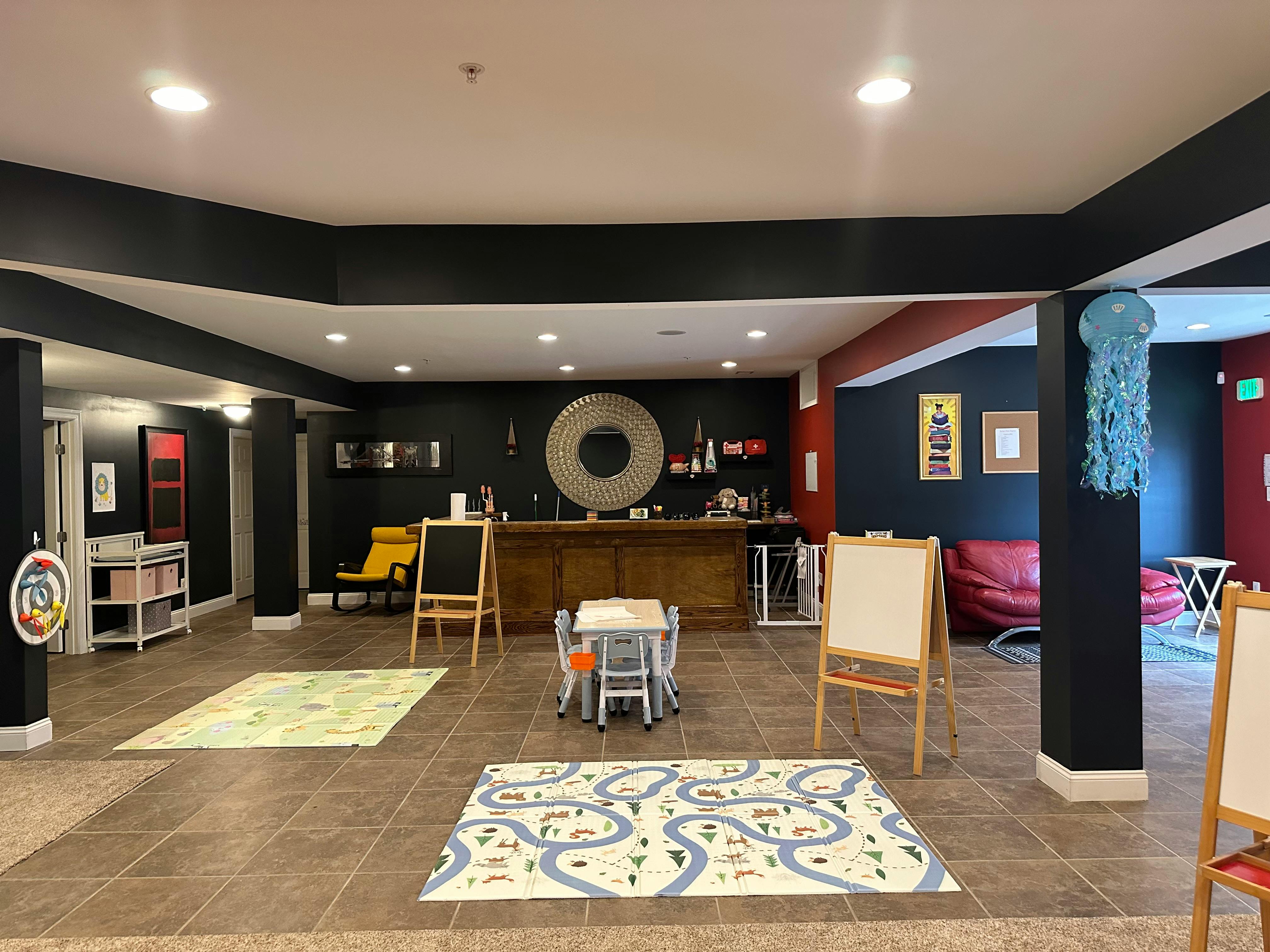Playroom with rugs, easels, and small tables