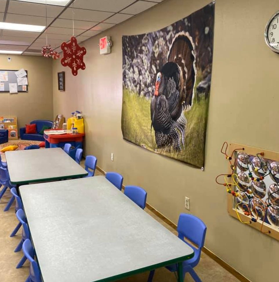 Classroom with tables and chairs, turkey tapestry on wall
