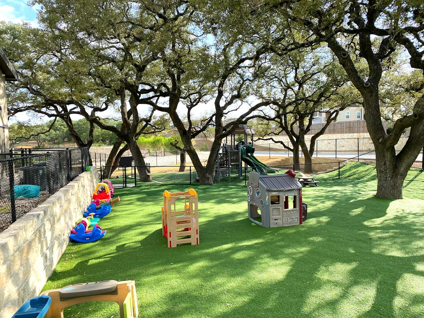 Children's playground with plastic play equipment and trees