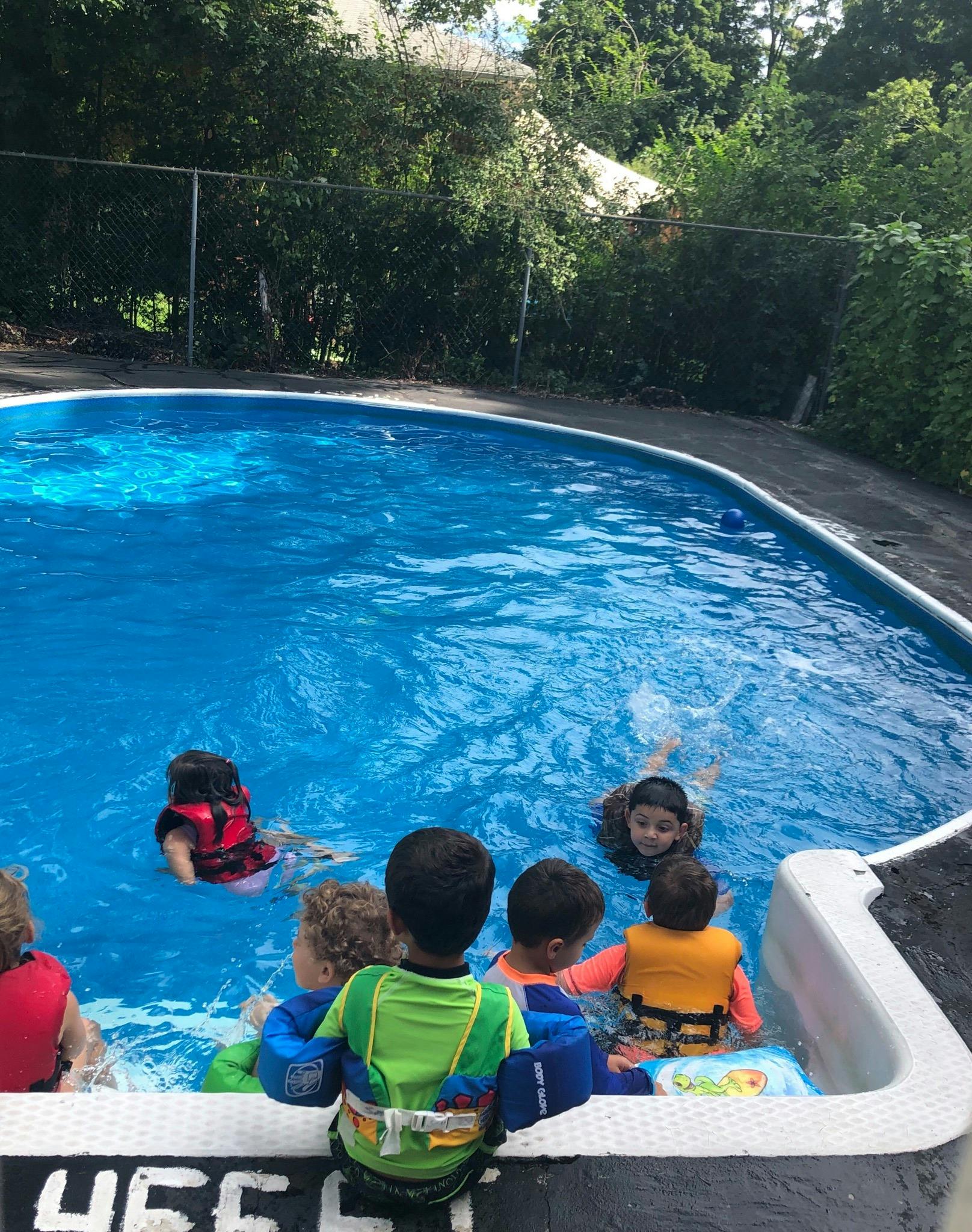 Children in life vests playing in a swimming pool