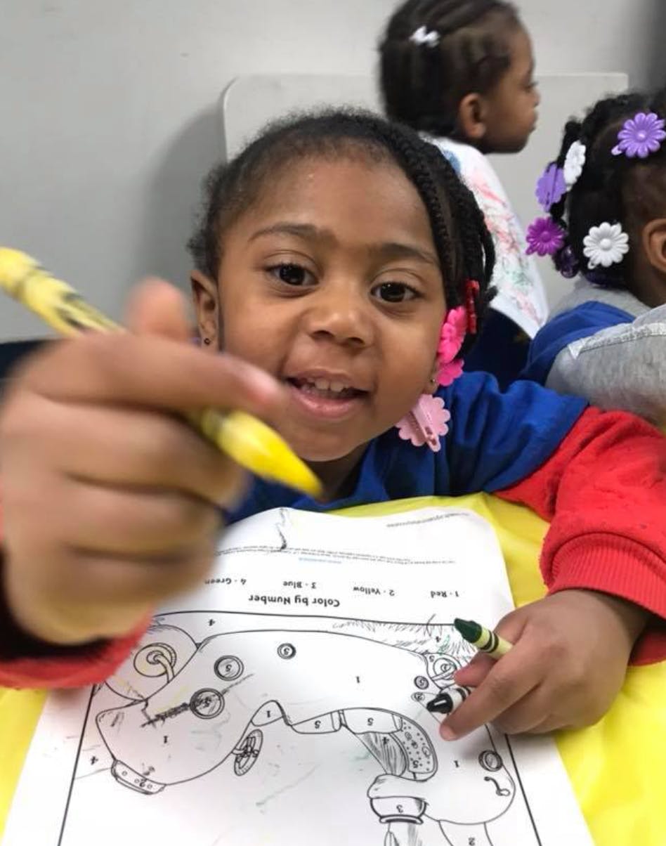 Child coloring a picture with crayons