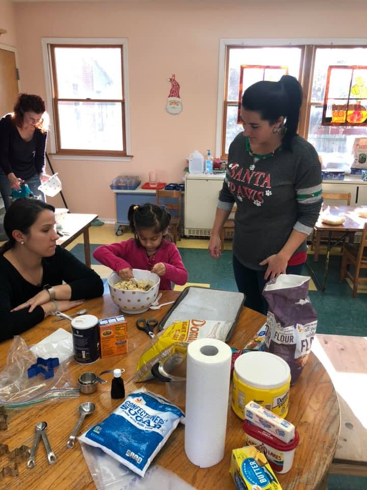 People and a child mixing ingredients at a table