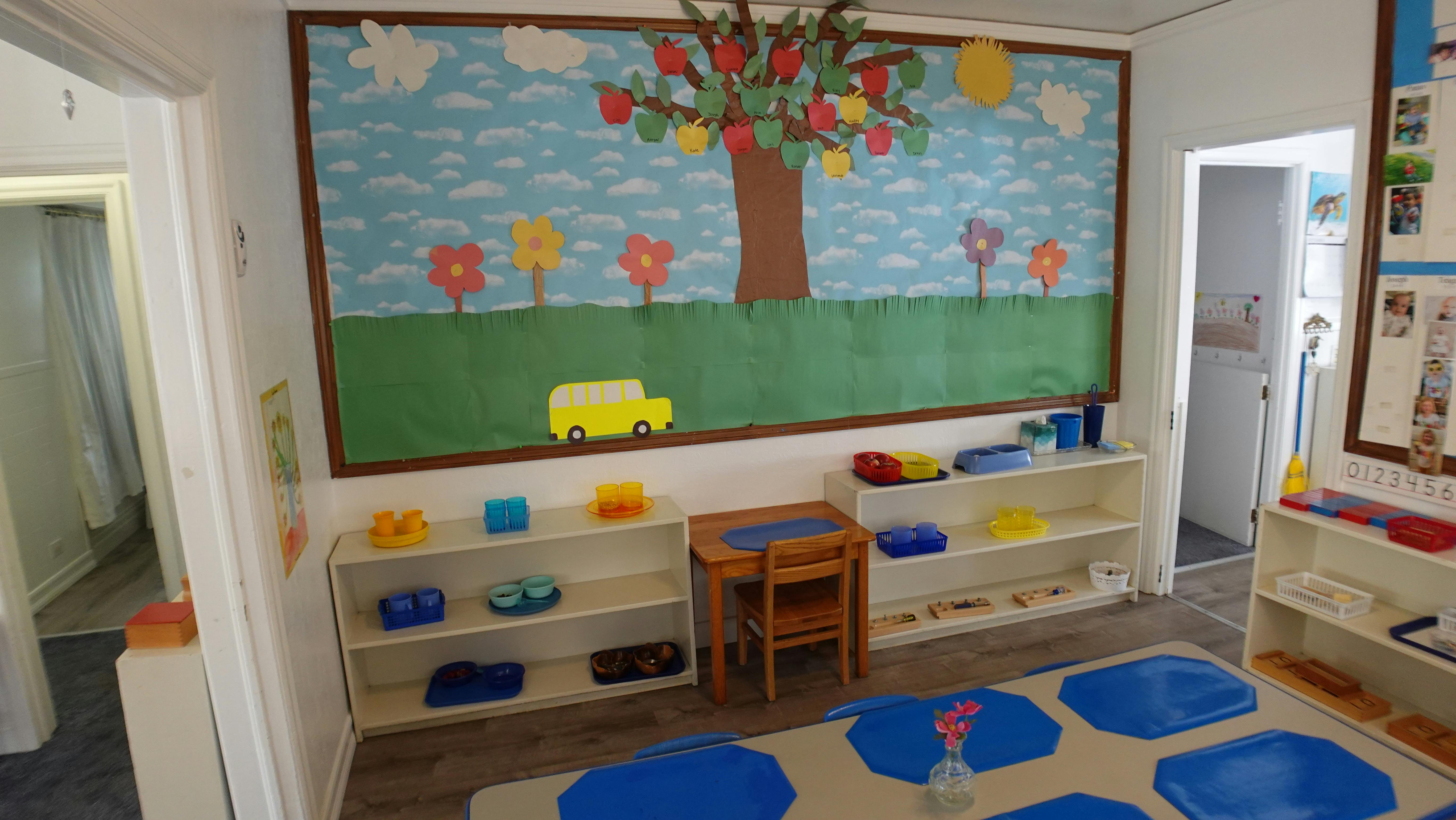Classroom with a large bulletin board mural of a tree and a yellow car