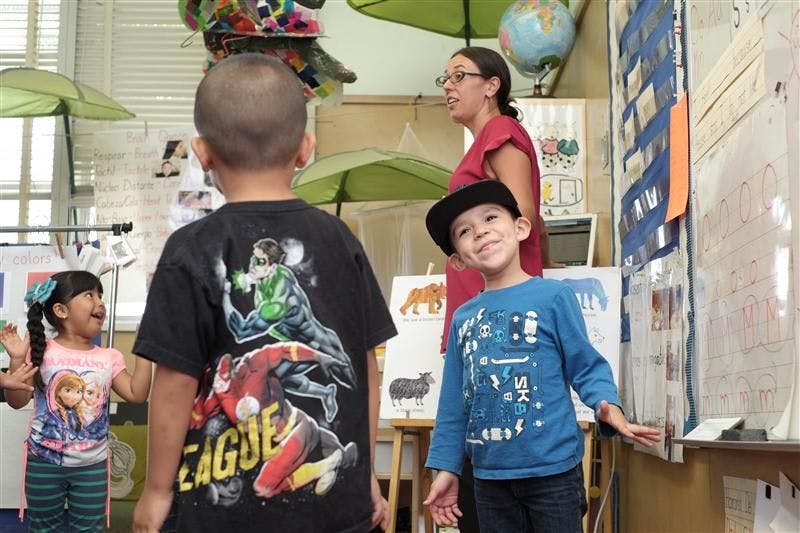 Adult and three children in a classroom