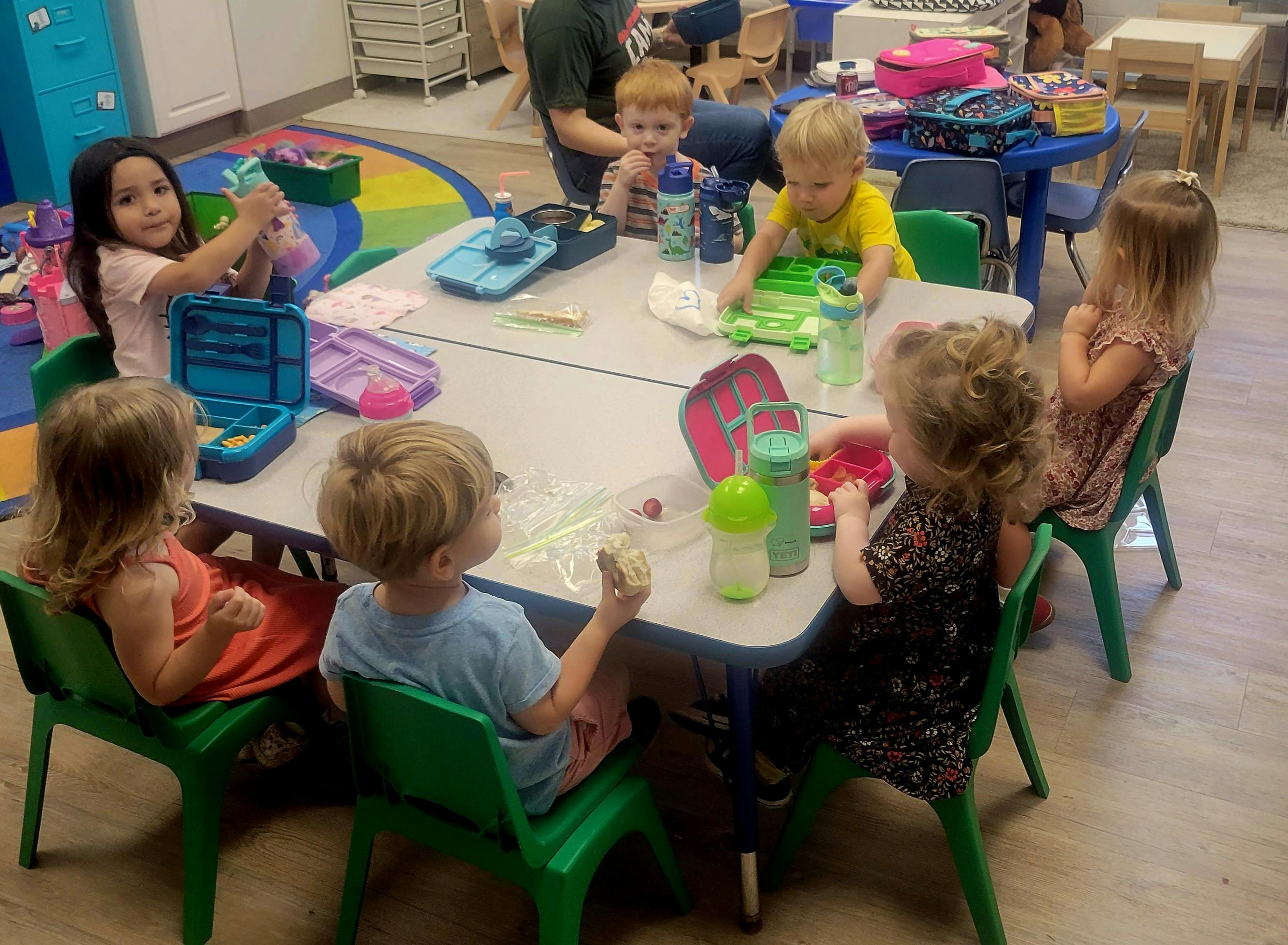 Children sitting at a table in a classroom