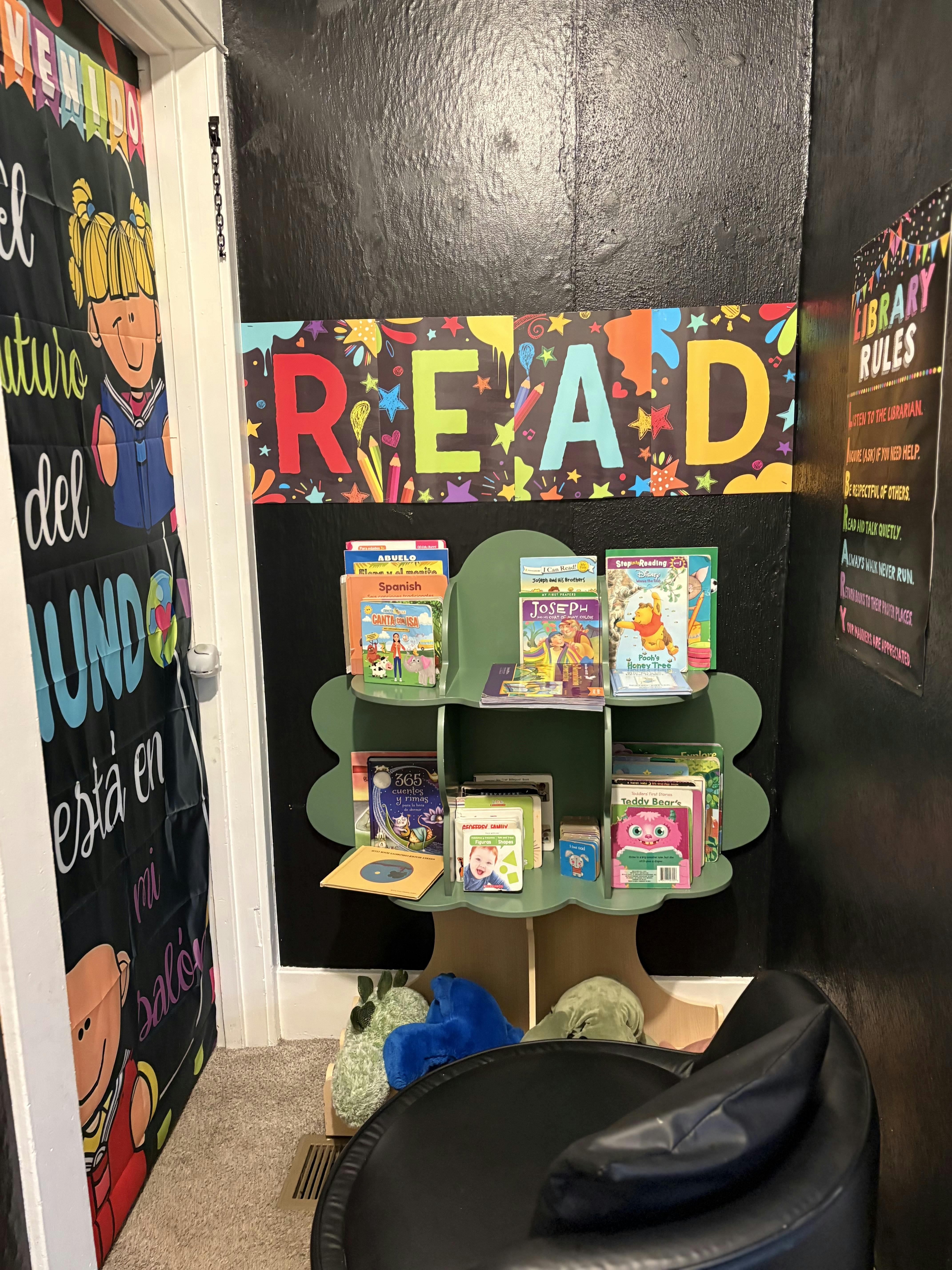 Small library corner with a green bookshelf containing children's books