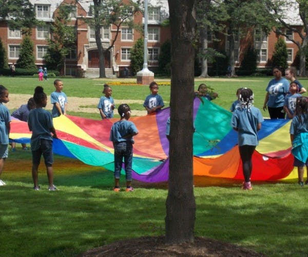 Children playing with a colorful parachute on a grassy field