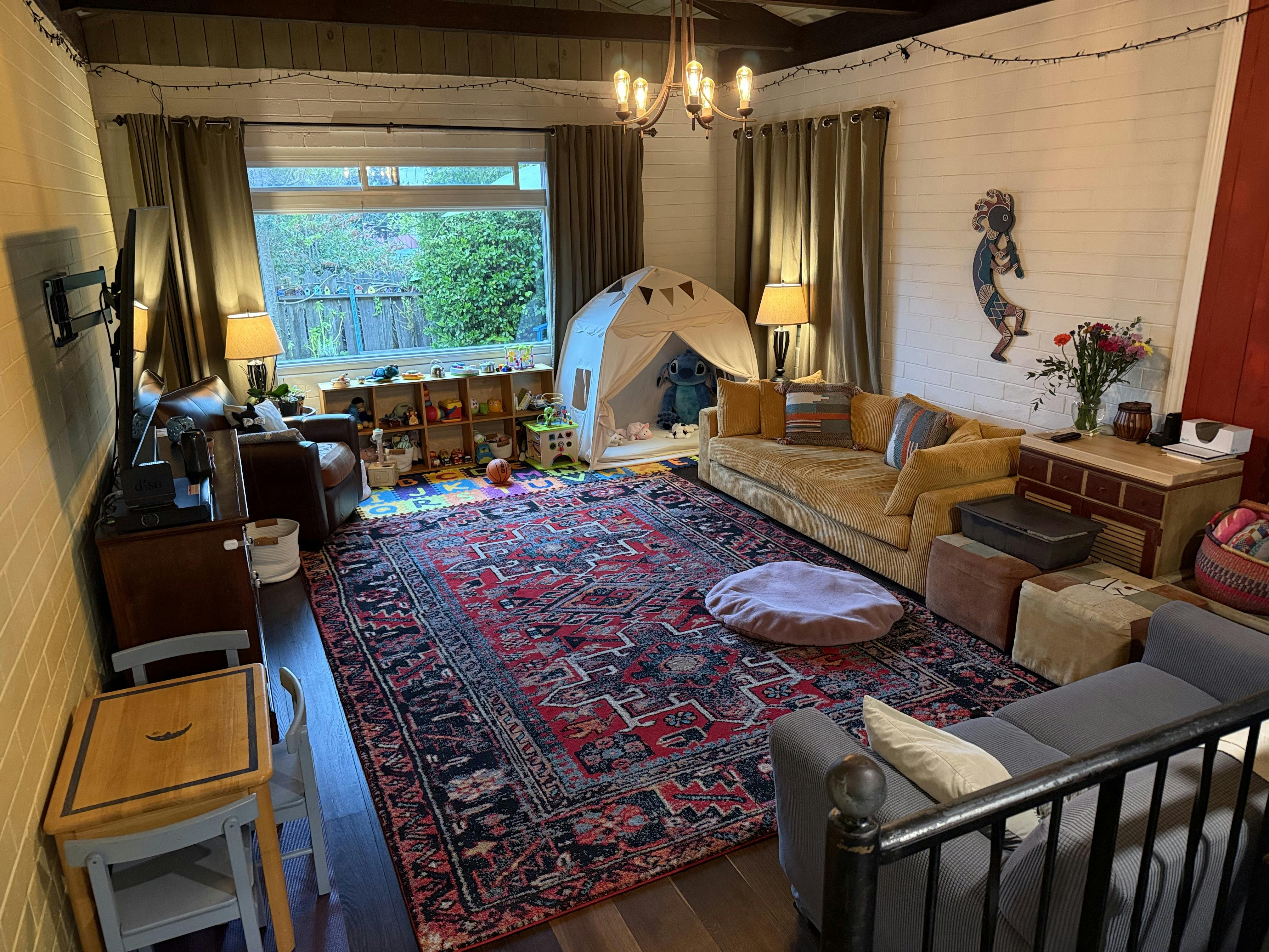 Living room with couches, a large patterned rug, and a child play tent