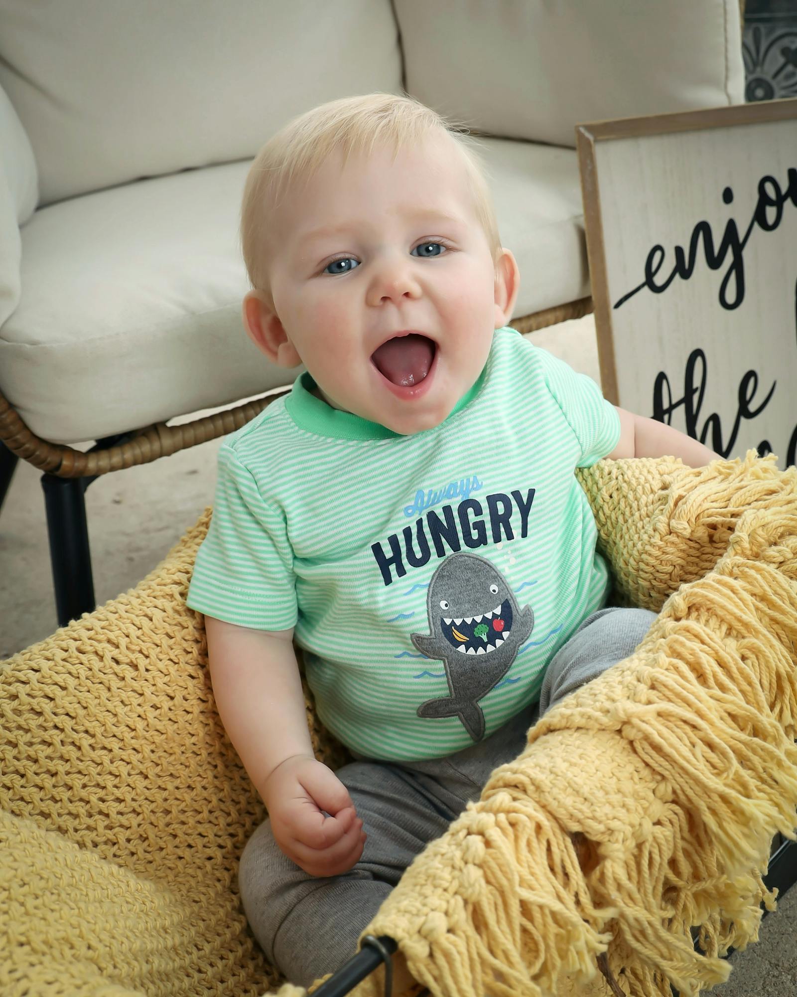 Child wearing a striped shirt with a shark graphic, mouth open