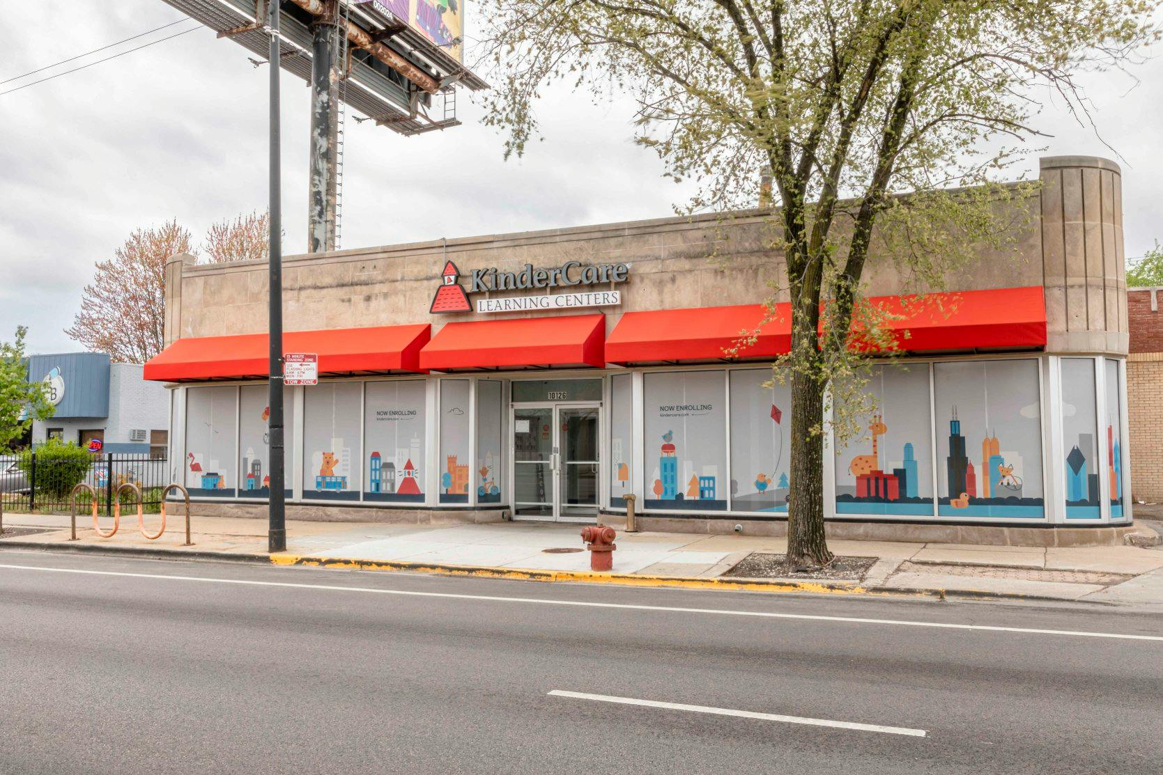 KinderCare Learning Centers building with red awnings and decorative window clings