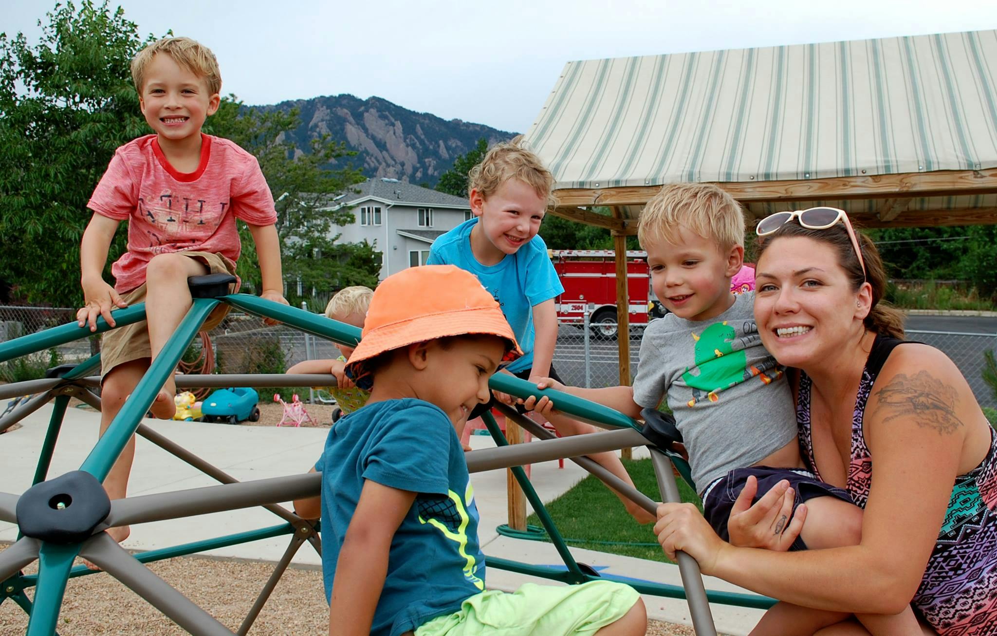 Adult and children on playground climbing structure