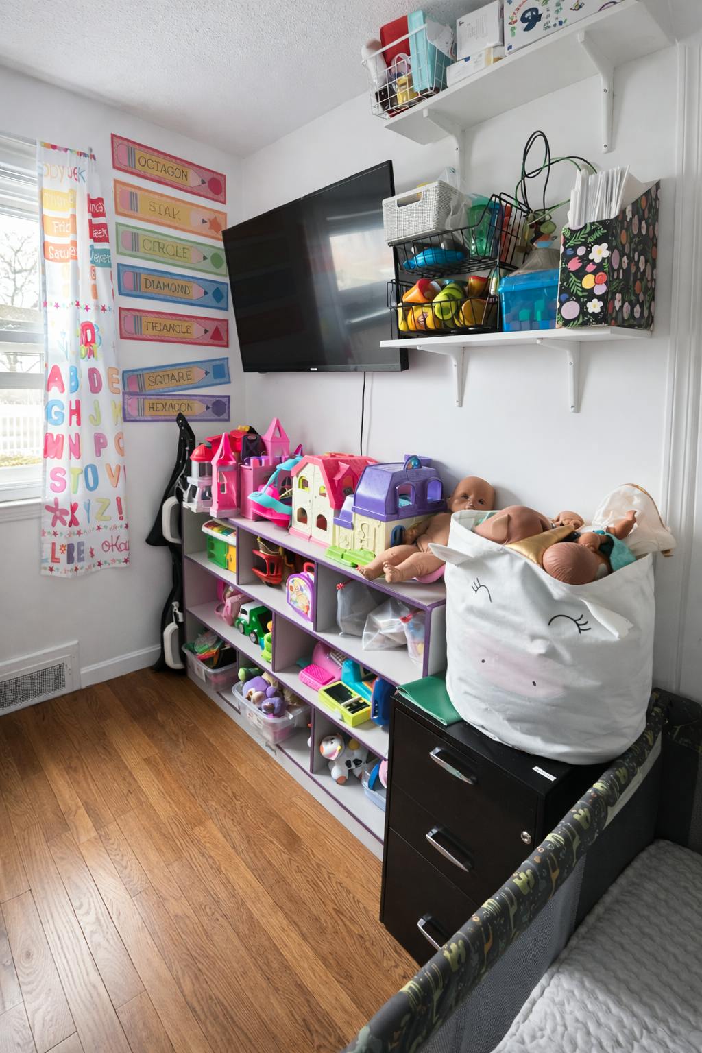 Children's room with toy shelves, crib, and wall-mounted TV