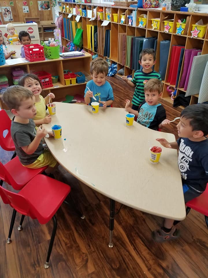 Children sitting at a table eating from a high angle view