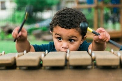 Child playing a xylophone with mallets