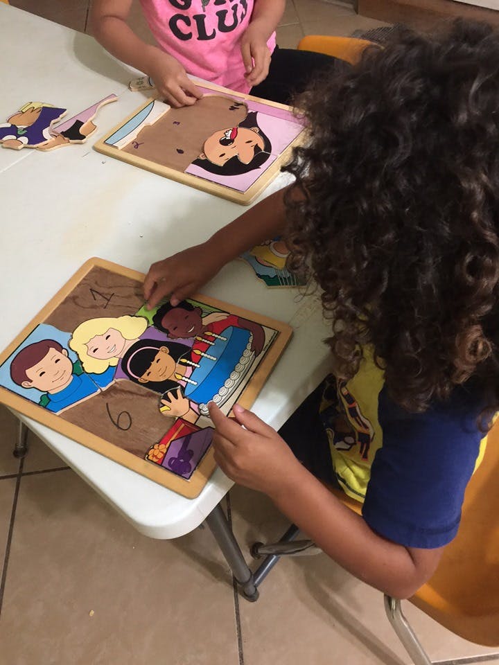 Child playing with a puzzle on a table