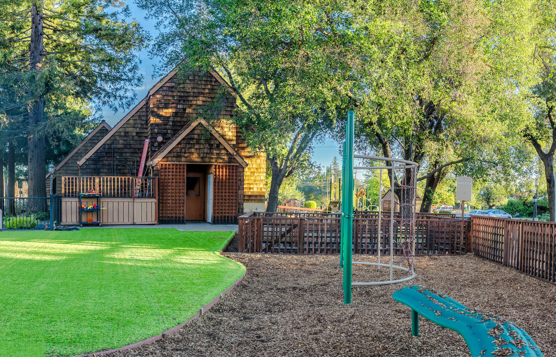 Playground with wooden building and climbing structure