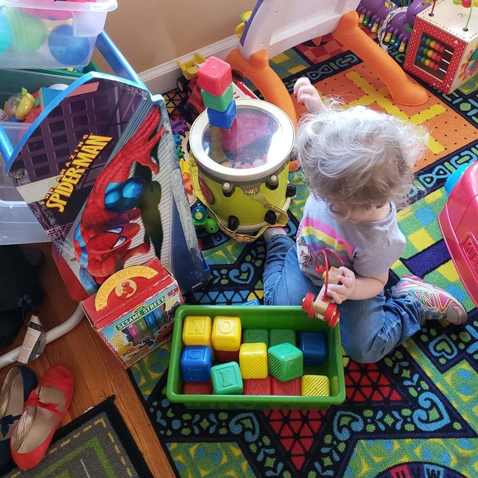Child playing with toys on a colorful rug