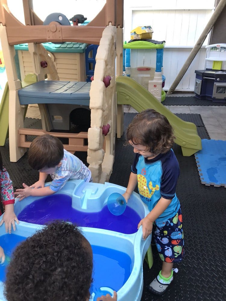 Children playing with water in a water table