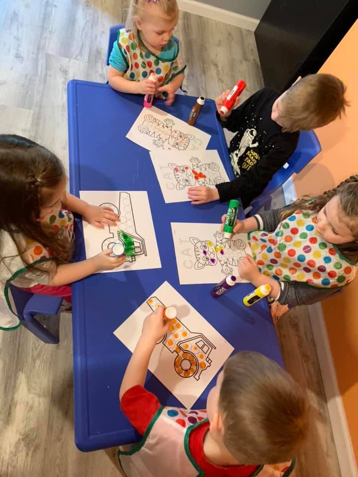 Children coloring at a blue table
