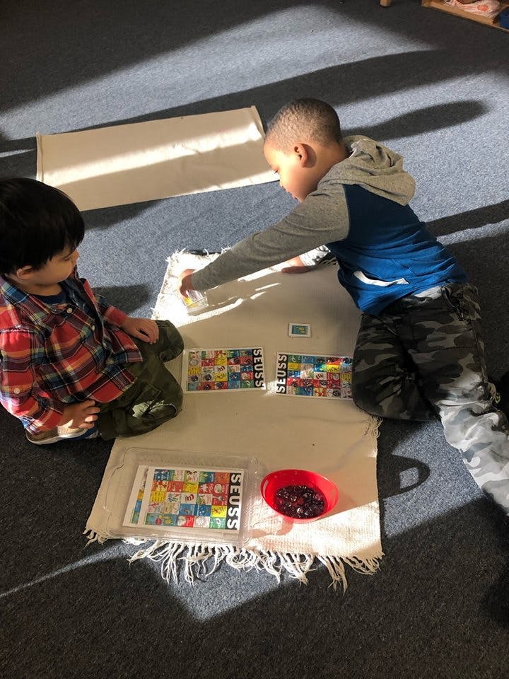 Two children playing a game on a mat on the floor