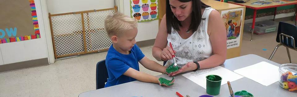 Adult and child painting in a classroom
