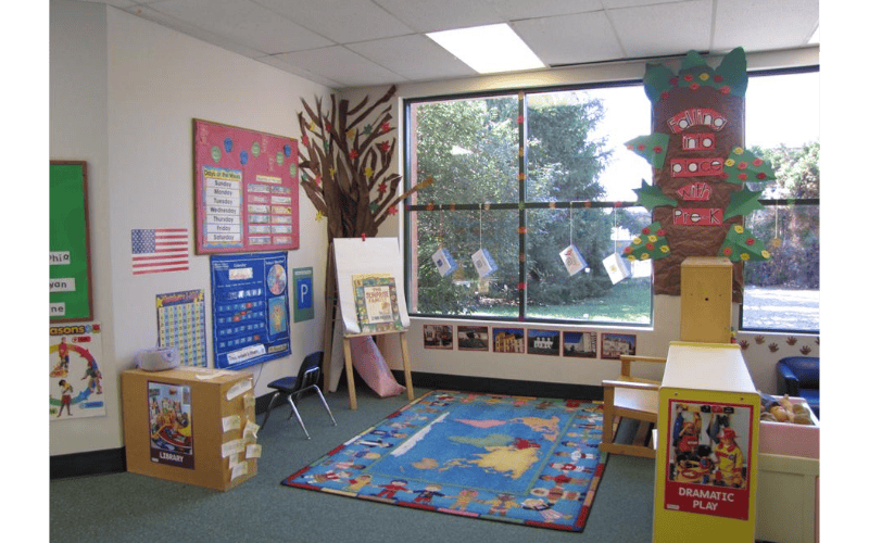 Children's classroom with decorated walls, world map rug, and large windows