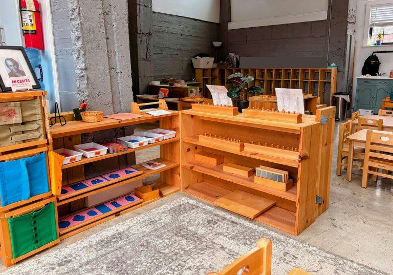 Wooden shelving units with educational materials in a preschool classroom