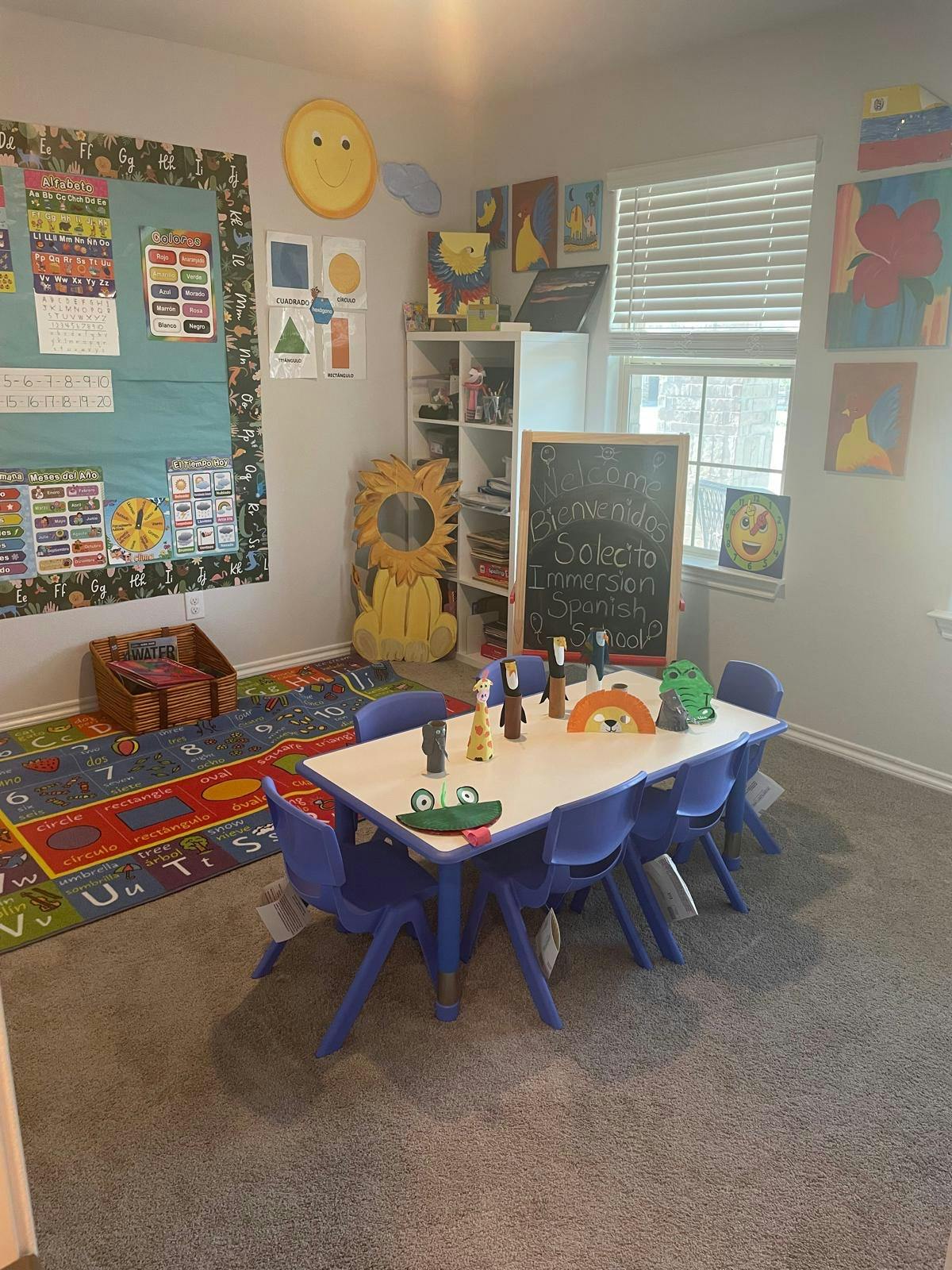 Classroom with a small table and chairs, a colorful rug, and a bulletin board