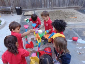 Children playing with a water table outdoors