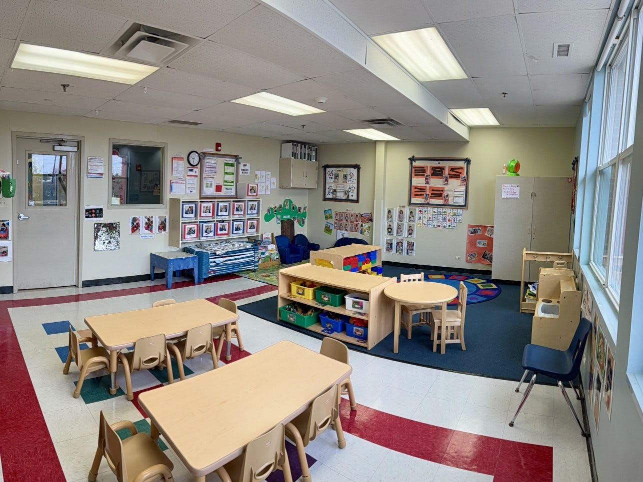 Empty classroom with small tables, chairs, and colorful decorations