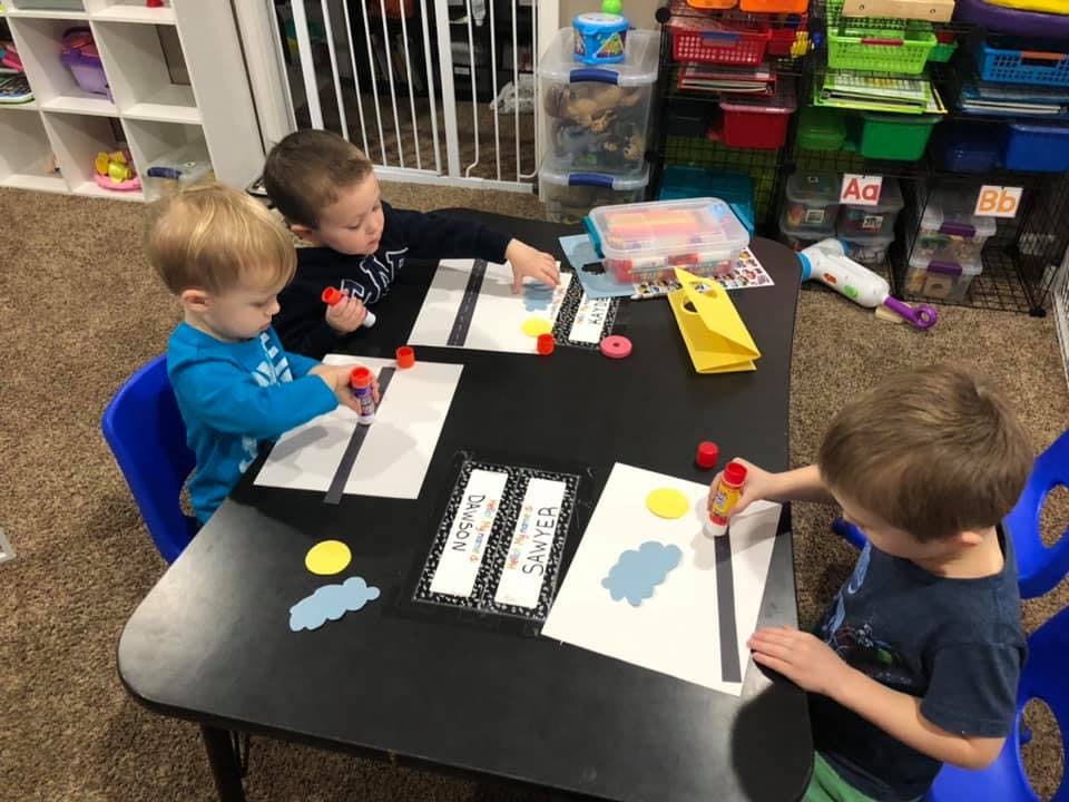Three children doing an art activity at a table