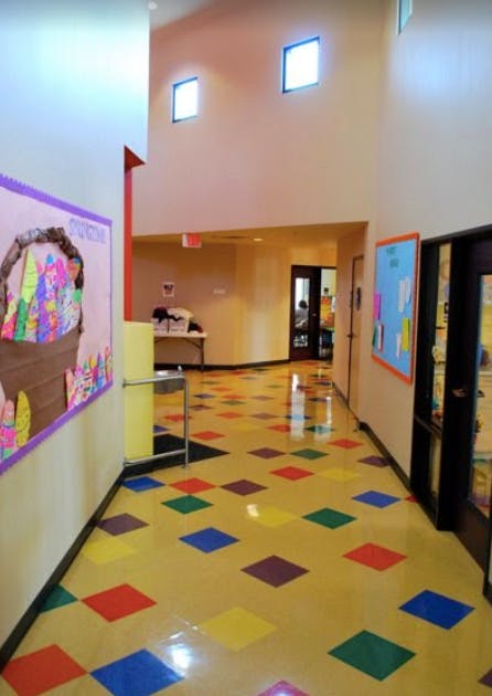 Hallway with colorful diamond-patterned floor tiles and bulletin boards