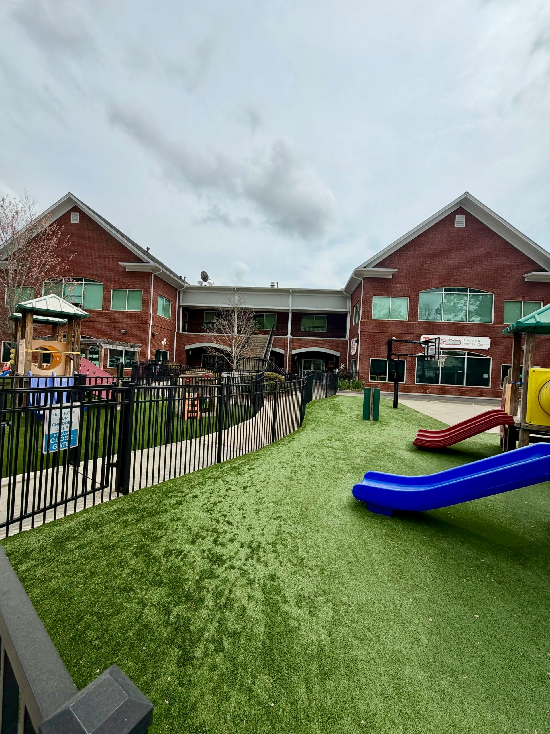 Playground with slides and equipment at a brick building learning center