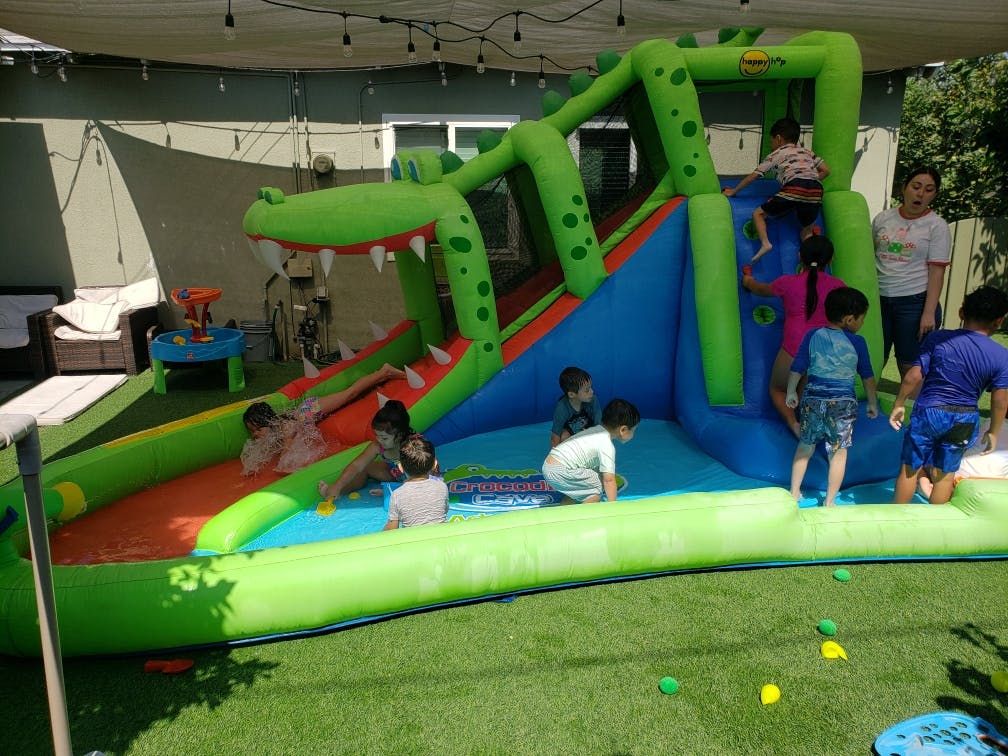 Children playing in a crocodile-themed inflatable water park
