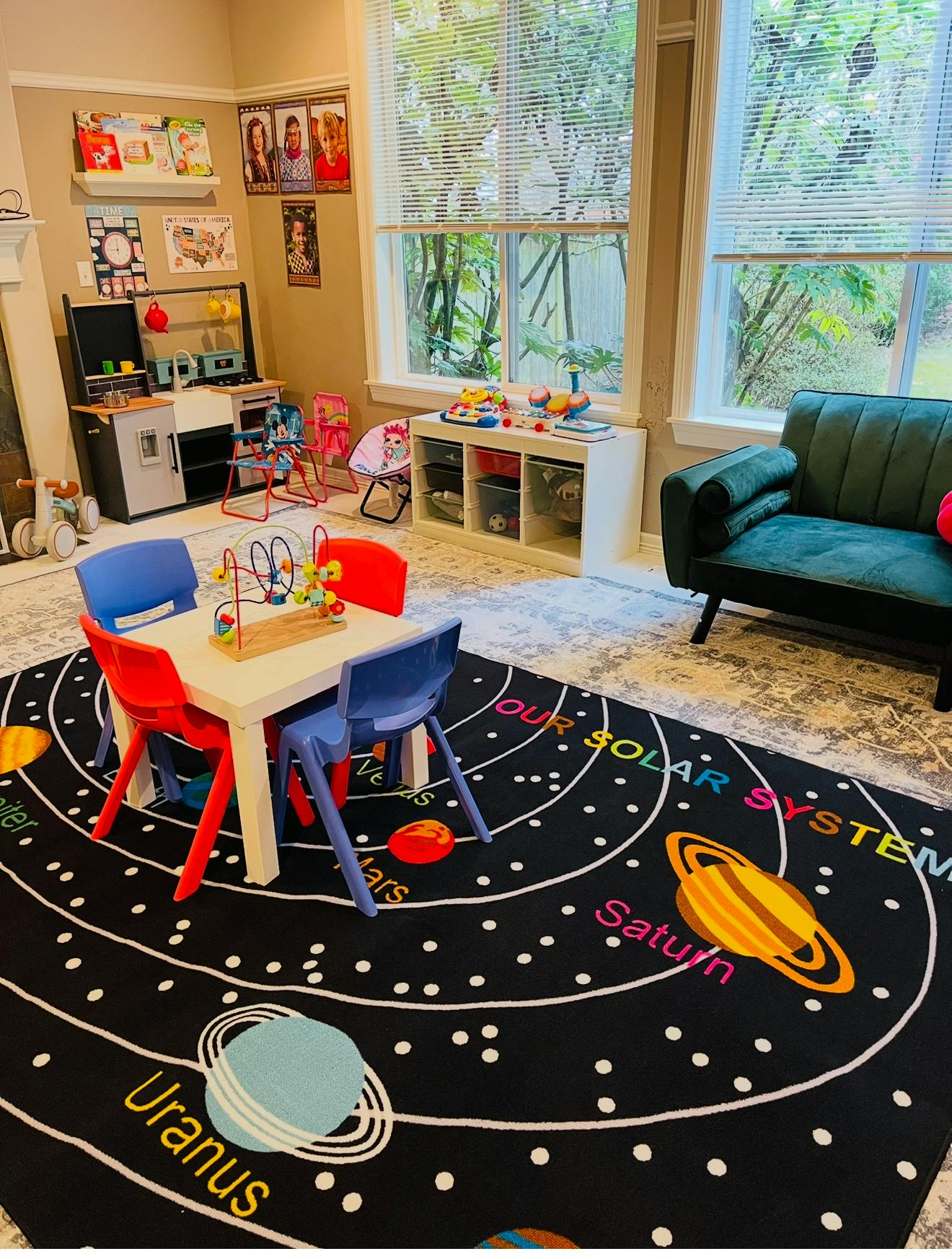 Playroom with a solar system rug, small table and chairs, and toys
