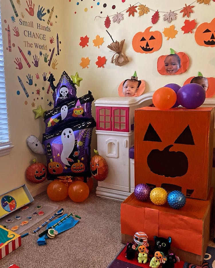 Halloween decorations with pumpkins, ghosts, and balloons in-image text "Small Hands Change The World"