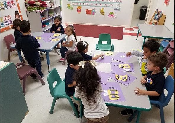 Children sitting at tables in a classroom